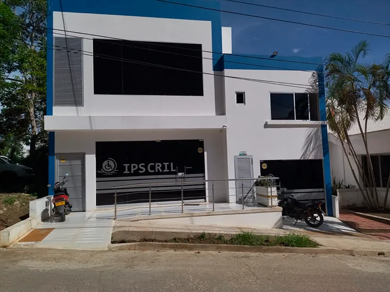 Fachada de la sede de IPS CRIL, edificio blanco de dos pisos con franja azul